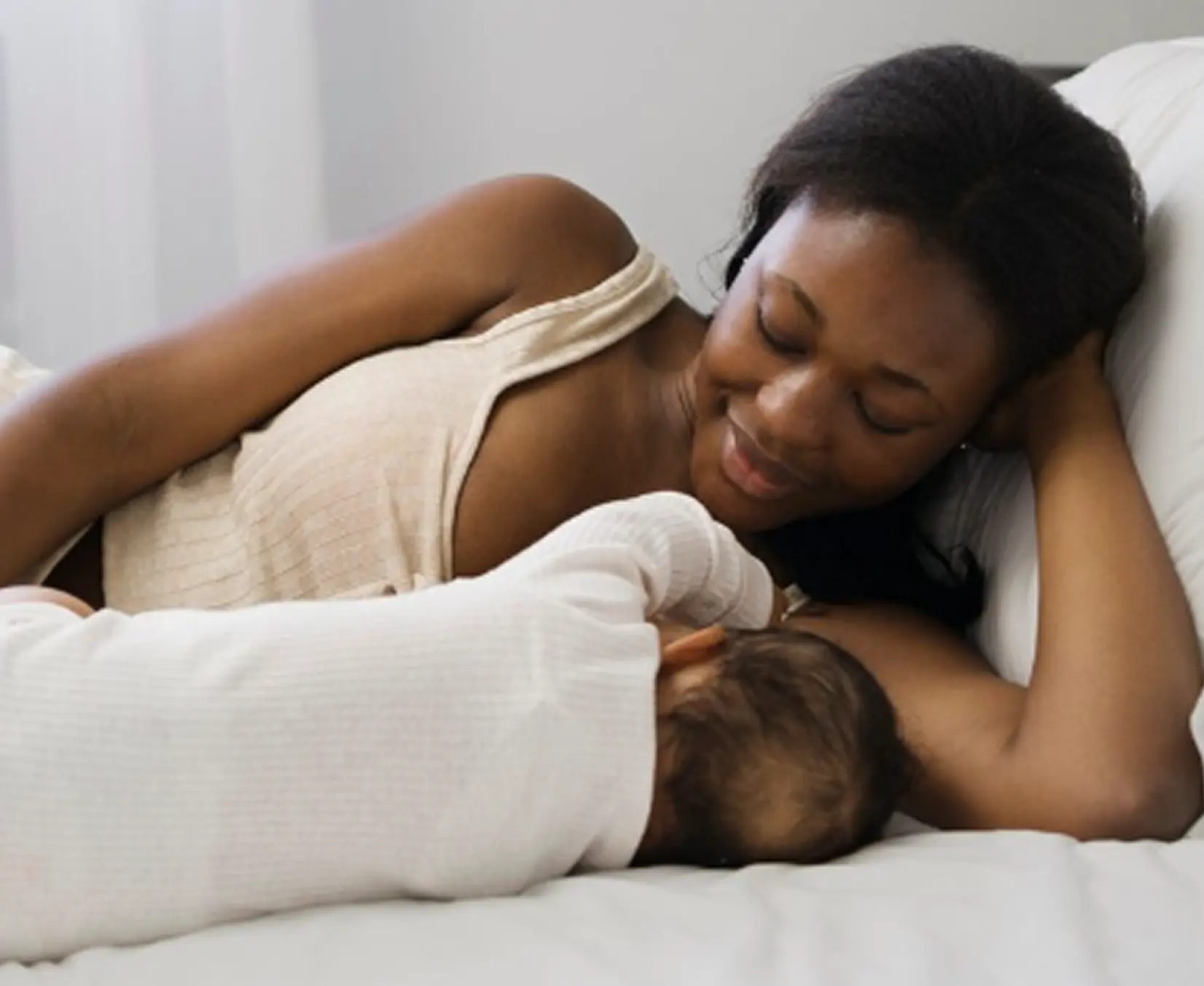 Mother resting in bed with her newborn